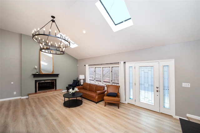 485 Harbor Rd, Cold Spring Harbor, NY 11724 - living area with vaulted ceiling, a glass covered fireplace, light wood-style floors, a skylight, and a chandelier