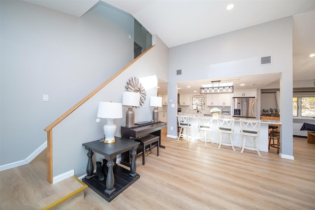 485 Harbor Rd, Cold Spring Harbor, NY 11724 - living room with light wood finished floors, recessed lighting, stairway, and a high ceiling