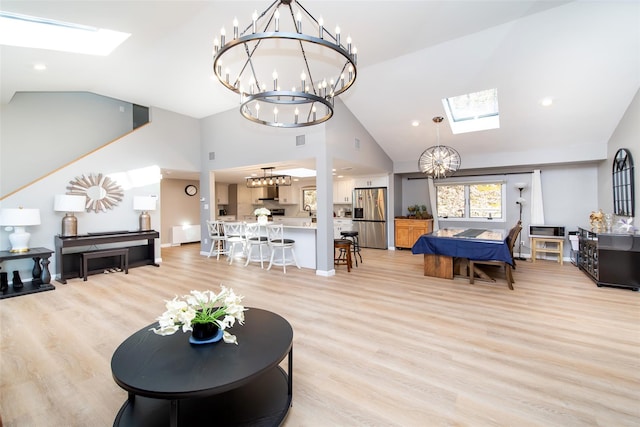 485 Harbor Rd, Cold Spring Harbor, NY 11724 - living room with a skylight, a chandelier, high vaulted ceiling, and light wood-type flooring
