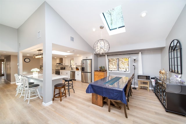 485 Harbor Rd, Cold Spring Harbor, NY 11724 - dining room with a chandelier, light wood finished floors, a skylight, high vaulted ceiling, and recessed lighting