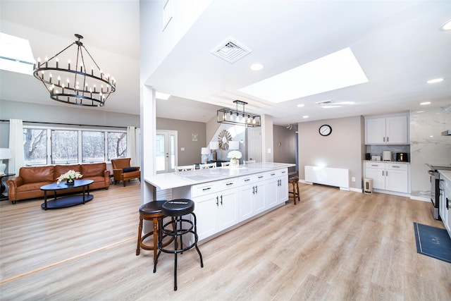 485 Harbor Rd, Cold Spring Harbor, NY 11724 - kitchen featuring a chandelier, open floor plan, a breakfast bar, light stone counters, and recessed lighting