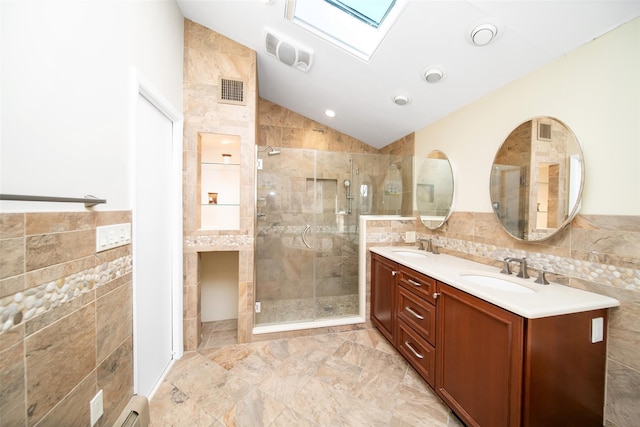 485 Harbor Rd, Cold Spring Harbor, NY 11724 - bathroom with tile walls, a skylight, lofted ceiling, double vanity, and a shower stall
