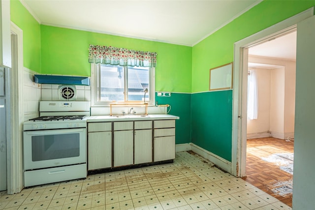 2 Florence St, North Baldwin, NY 11510 - kitchen featuring white range with gas stovetop, crown molding, under cabinet range hood, and light countertops