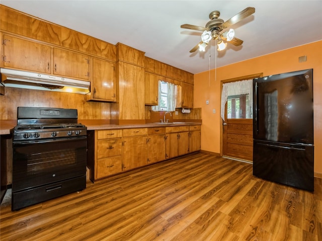 10 Vail Ave, Beacon, NY 12508 - kitchen with under cabinet range hood, black appliances, ceiling fan, dark wood finished floors, and brown cabinetry