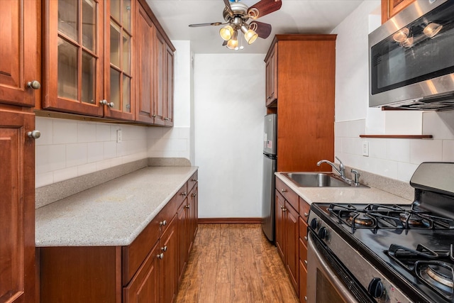 89-40 151st Ave Unit 1M, Howard Beach, NY 11414 - kitchen featuring appliances with stainless steel finishes, light wood-style floors, decorative backsplash, and brown cabinets