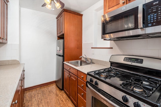 89-40 151st Ave Unit 1M, Howard Beach, NY 11414 - kitchen featuring appliances with stainless steel finishes, brown cabinetry, light wood-style flooring, and light countertops
