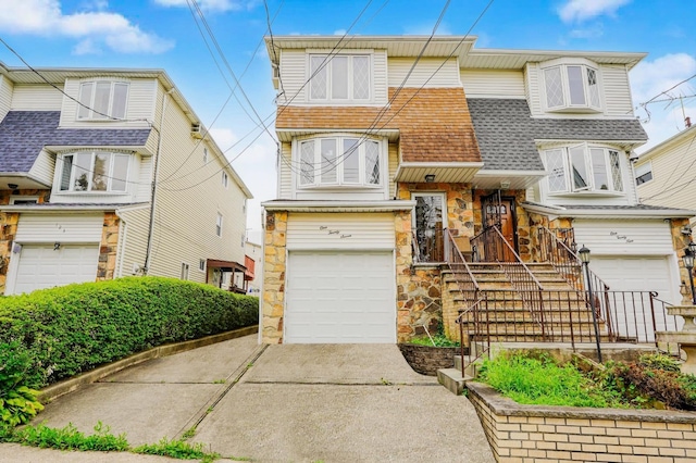 127 Keating Pl, Staten Island, NY 10314 - view of front facade with stone siding, an attached garage, driveway, and a shingled roof