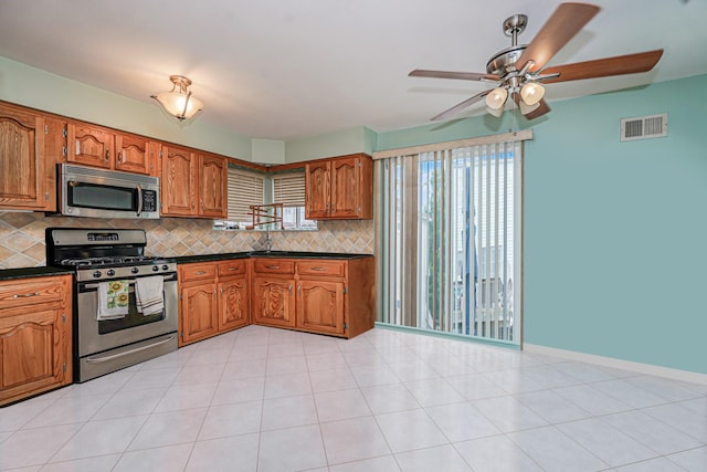 127 Keating Pl, Staten Island, NY 10314 - kitchen with stainless steel appliances, dark countertops, decorative backsplash, and brown cabinets