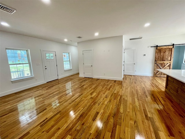 109 Krystyna Rd, White Lake, NY 12787 - unfurnished living room featuring a barn door, light wood-type flooring, and recessed lighting