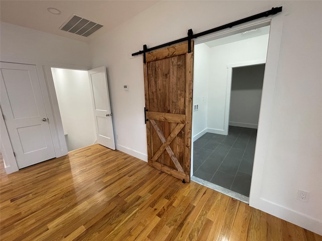 109 Krystyna Rd, White Lake, NY 12787 - unfurnished bedroom with a barn door and wood finished floors