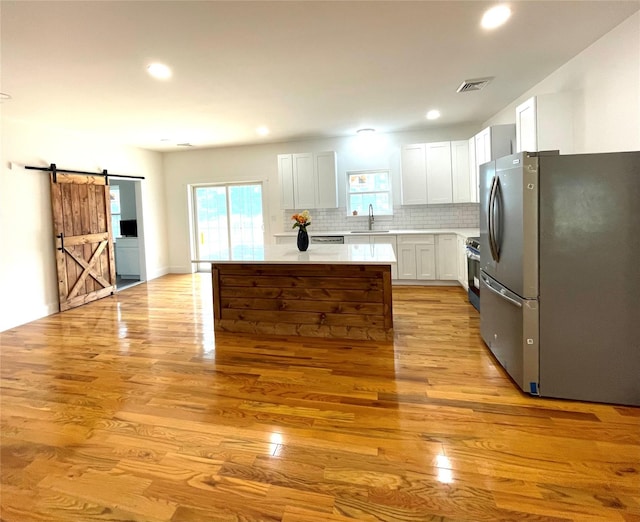 109 Krystyna Rd, White Lake, NY 12787 - kitchen with stainless steel appliances, a barn door, light countertops, a center island, and light wood-style floors