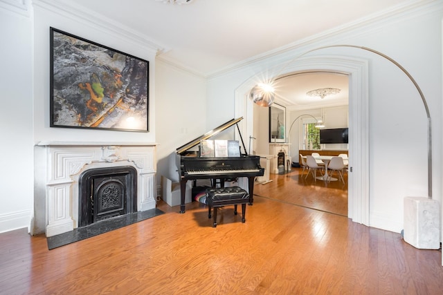 17E 128th St, New York Manhattan, NY 10035 - living area with crown molding, wood finished floors, a high end fireplace, and a chandelier