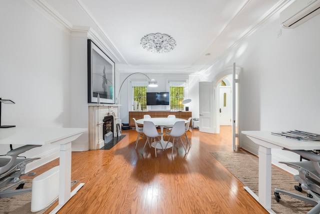 17E 128th St, New York Manhattan, NY 10035 - dining space featuring a wall mounted air conditioner, light wood-style flooring, a fireplace with flush hearth, a raised ceiling, and ornamental molding
