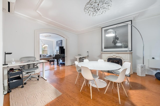 17E 128th St, New York Manhattan, NY 10035 - dining room with light wood-style floors, crown molding, a glass covered fireplace, arched walkways, and an office area
