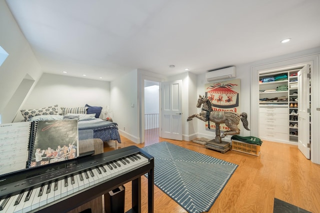 17E 128th St, New York Manhattan, NY 10035 - bedroom featuring an AC wall unit, wood finished floors, recessed lighting, and a spacious closet