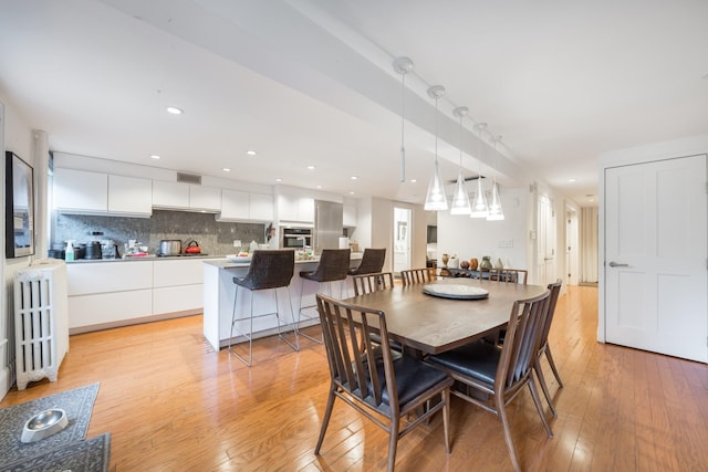 17E 128th St, New York Manhattan, NY 10035 - dining room featuring radiator heating unit, light wood-style flooring, and recessed lighting