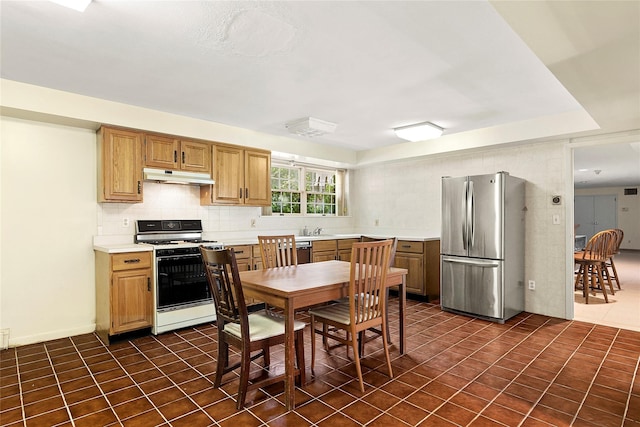 14 Pheasant Hill Ln, Old Brookville, NY 11545 - kitchen with appliances with stainless steel finishes, under cabinet range hood, light countertops, tasteful backsplash, and dark tile patterned flooring