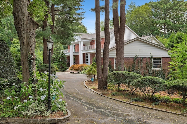 14 Pheasant Hill Ln, Old Brookville, NY 11545 - greek revival house with brick siding, a balcony, and asphalt driveway