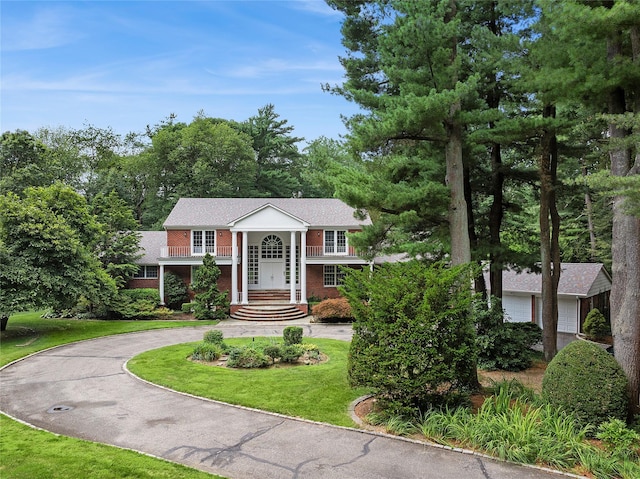 14 Pheasant Hill Ln, Old Brookville, NY 11545 - greek revival house with brick siding, a front lawn, and curved driveway