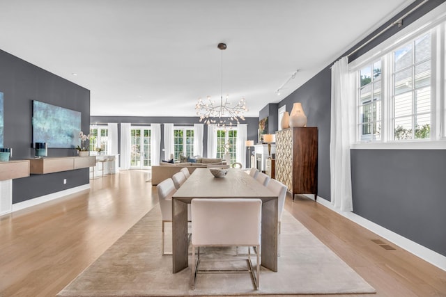 7 Honeysuckle Ln, Rye Brook, NY 10573 - dining room with rail lighting, wood finished floors, and a chandelier
