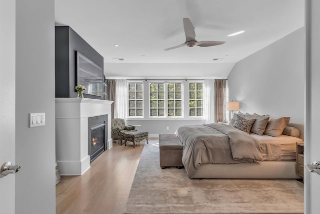 7 Honeysuckle Ln, Rye Brook, NY 10573 - bedroom featuring wood finished floors, a glass covered fireplace, ceiling fan, and vaulted ceiling