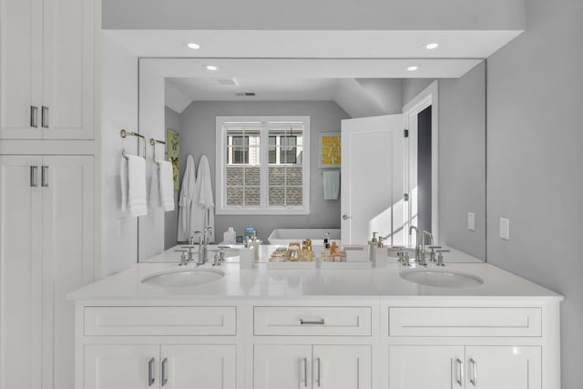 7 Honeysuckle Ln, Rye Brook, NY 10573 - full bathroom featuring double vanity, vaulted ceiling, and recessed lighting