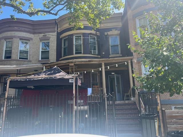 679 Georgia Ave, Brooklyn, NY 11207 - rear view of house featuring a fenced front yard, a gate, and a porch