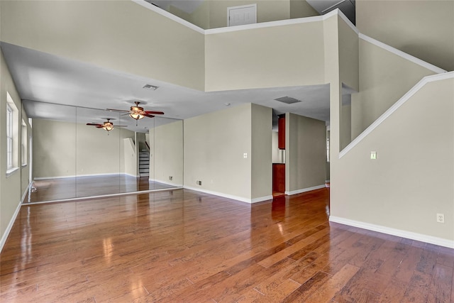 23 Indian Trce, Kings Park, NY 11754 - unfurnished living room with ceiling fan, wood finished floors, stairs, and a towering ceiling