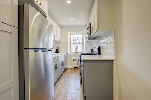 144-60 Gravett Rd Unit 4J, Kew Garden Hills, NY 11367 - kitchen featuring appliances with stainless steel finishes, light countertops, gray cabinetry, recessed lighting, and backsplash