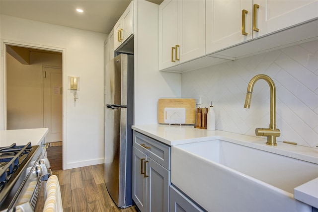 144-60 Gravett Rd Unit 4J, Kew Garden Hills, NY 11367 - kitchen with appliances with stainless steel finishes, decorative backsplash, light countertops, dark wood finished floors, and white cabinetry