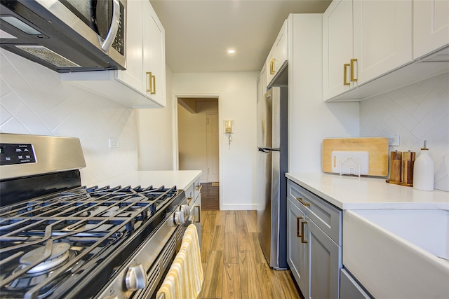 144-60 Gravett Rd Unit 4J, Kew Garden Hills, NY 11367 - kitchen featuring stainless steel appliances, light wood-style flooring, tasteful backsplash, light countertops, and recessed lighting