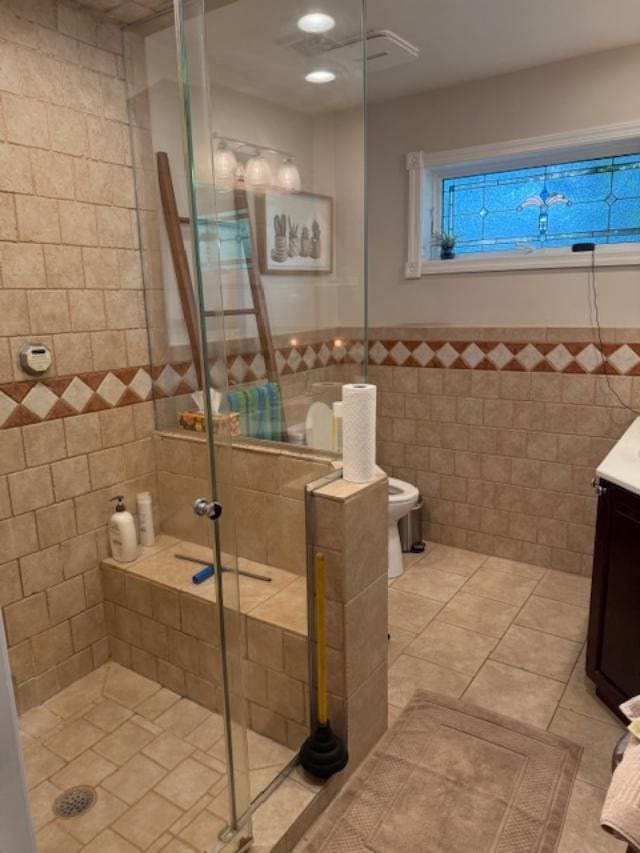 9 Seneca St E, Massapequa, NY 11758 - bathroom with tile walls, tile patterned flooring, vanity, a shower stall, and wainscoting