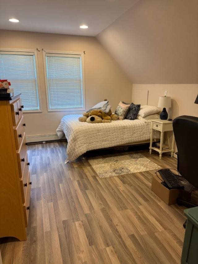 9 Seneca St E, Massapequa, NY 11758 - bedroom with a baseboard heating unit, wood finished floors, recessed lighting, vaulted ceiling, and multiple windows