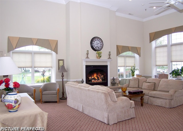 507 Constance Ln, Port Jefferson Station, NY 11776 - living area featuring a high ceiling, carpet flooring, a warm lit fireplace, ceiling fan, and crown molding