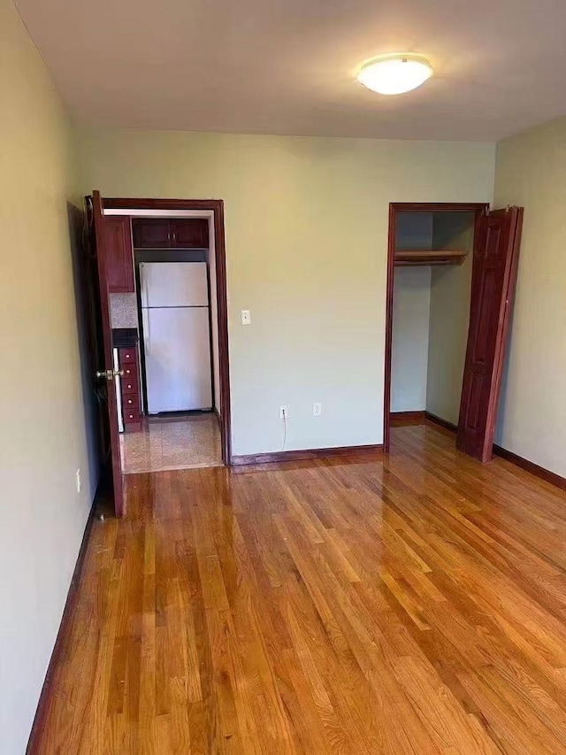 8827 53 Rd Ave Unit 2R, Elmhurst, NY 11373 - unfurnished bedroom featuring wood finished floors, freestanding refrigerator, and a closet