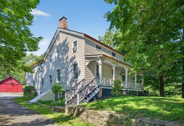 35 Everett Rd, Goshen, NY 10916 - view of front of home with covered porch, a chimney, an outdoor structure, a detached garage, and a front lawn