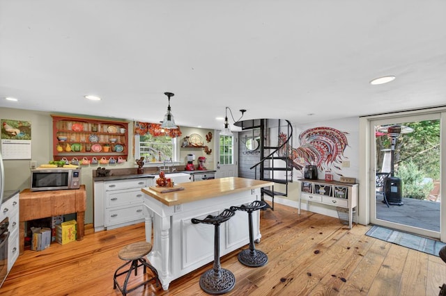 35 Everett Rd, Goshen, NY 10916 - kitchen with stainless steel microwave, light wood-type flooring, white cabinetry, open shelves, and recessed lighting