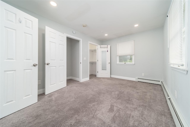 7 Miller Dr, Lake Grove, NY 11755 - unfurnished bedroom with a baseboard heating unit, carpet, a walk in closet, and recessed lighting