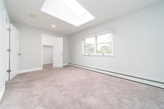 7 Miller Dr, Lake Grove, NY 11755 - unfurnished bedroom featuring a baseboard heating unit, light colored carpet, a skylight, recessed lighting, and a spacious closet