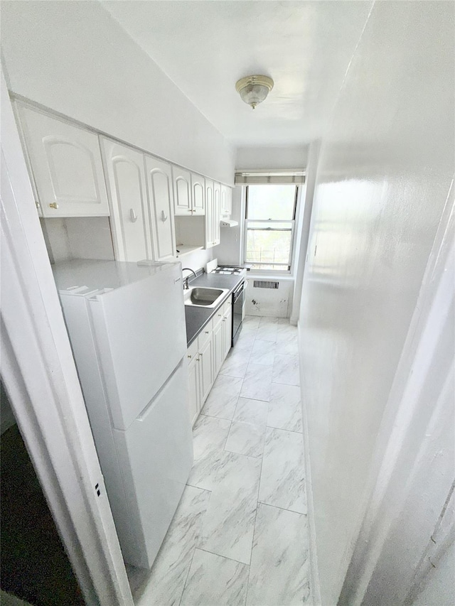 61-41 Saunders St Unit B44, Rego Park, NY 11374 - kitchen with light marble finish flooring, freestanding refrigerator, and white cabinetry