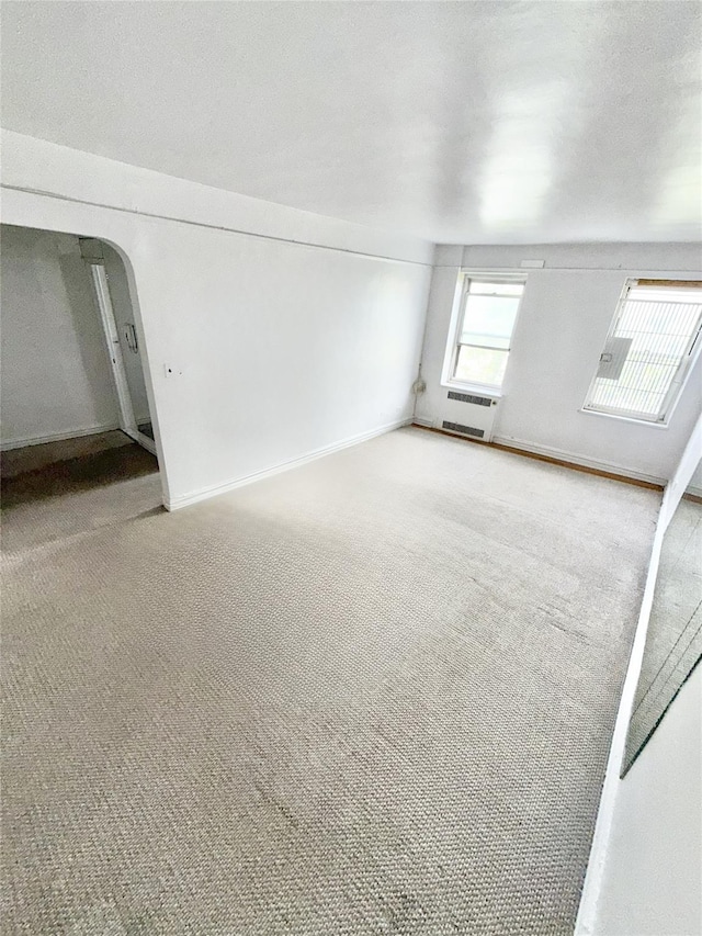 61-41 Saunders St Unit B44, Rego Park, NY 11374 - carpeted empty room with arched walkways and baseboards