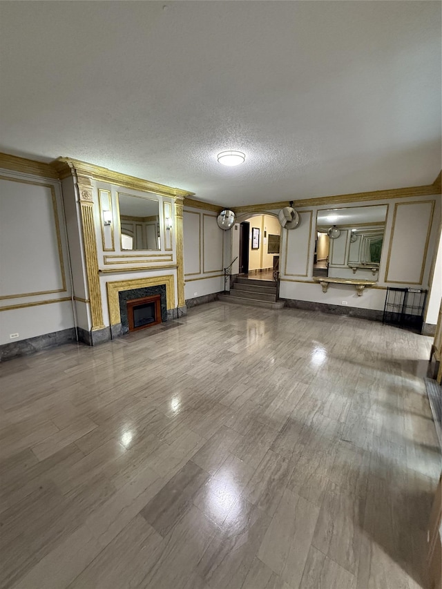 61-41 Saunders St Unit B44, Rego Park, NY 11374 - unfurnished living room with arched walkways, a fireplace, a textured ceiling, and wood finished floors