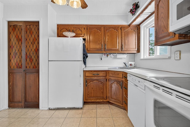 5 Clark St, Plainview, NY 11803 - kitchen with white appliances, brown cabinets, light countertops, light tile patterned floors, and ornamental molding