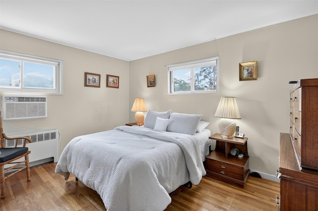 5 Clark St, Plainview, NY 11803 - bedroom with radiator heating unit, wood finished floors, and an AC wall unit