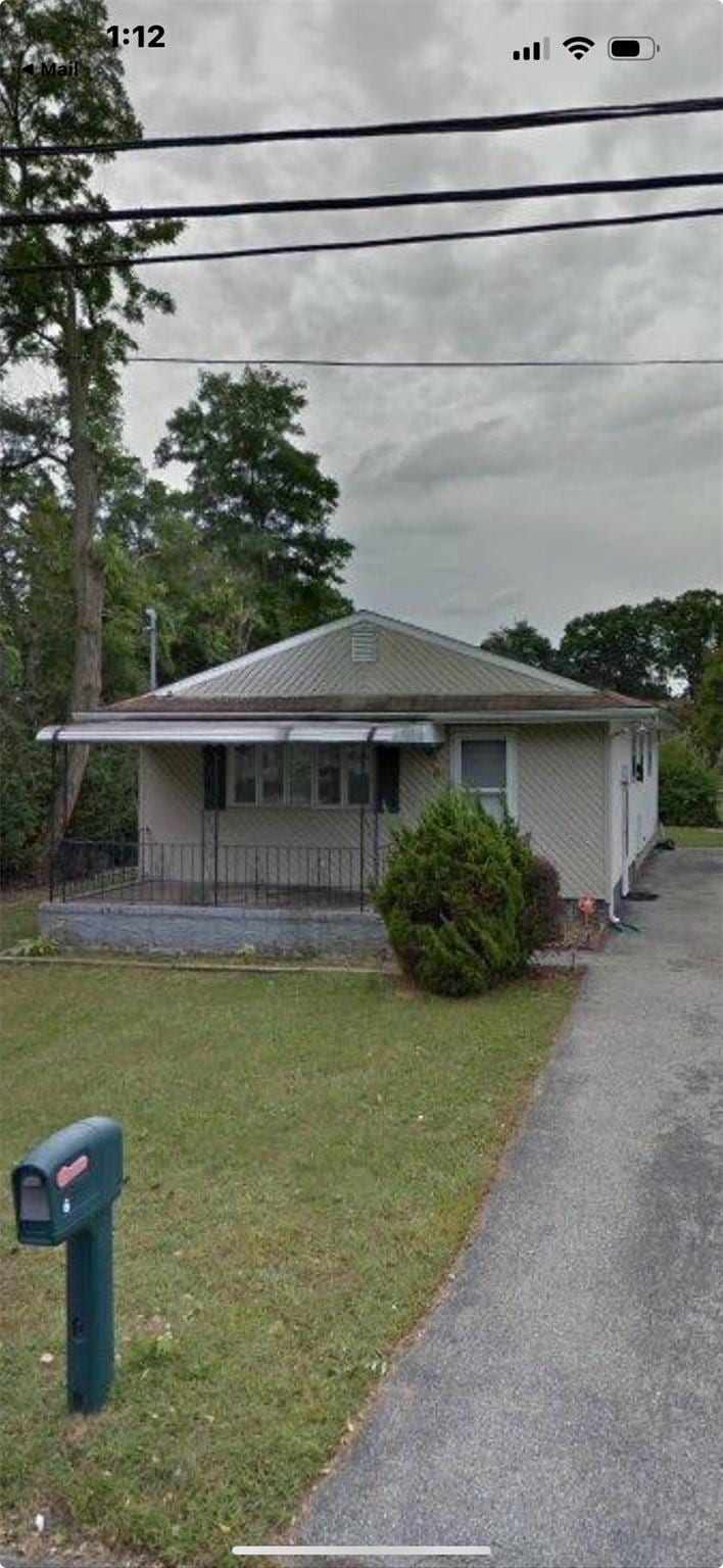 6 Poplar Rd, Amityville, NY 11701 - view of front of home with a porch and a front lawn