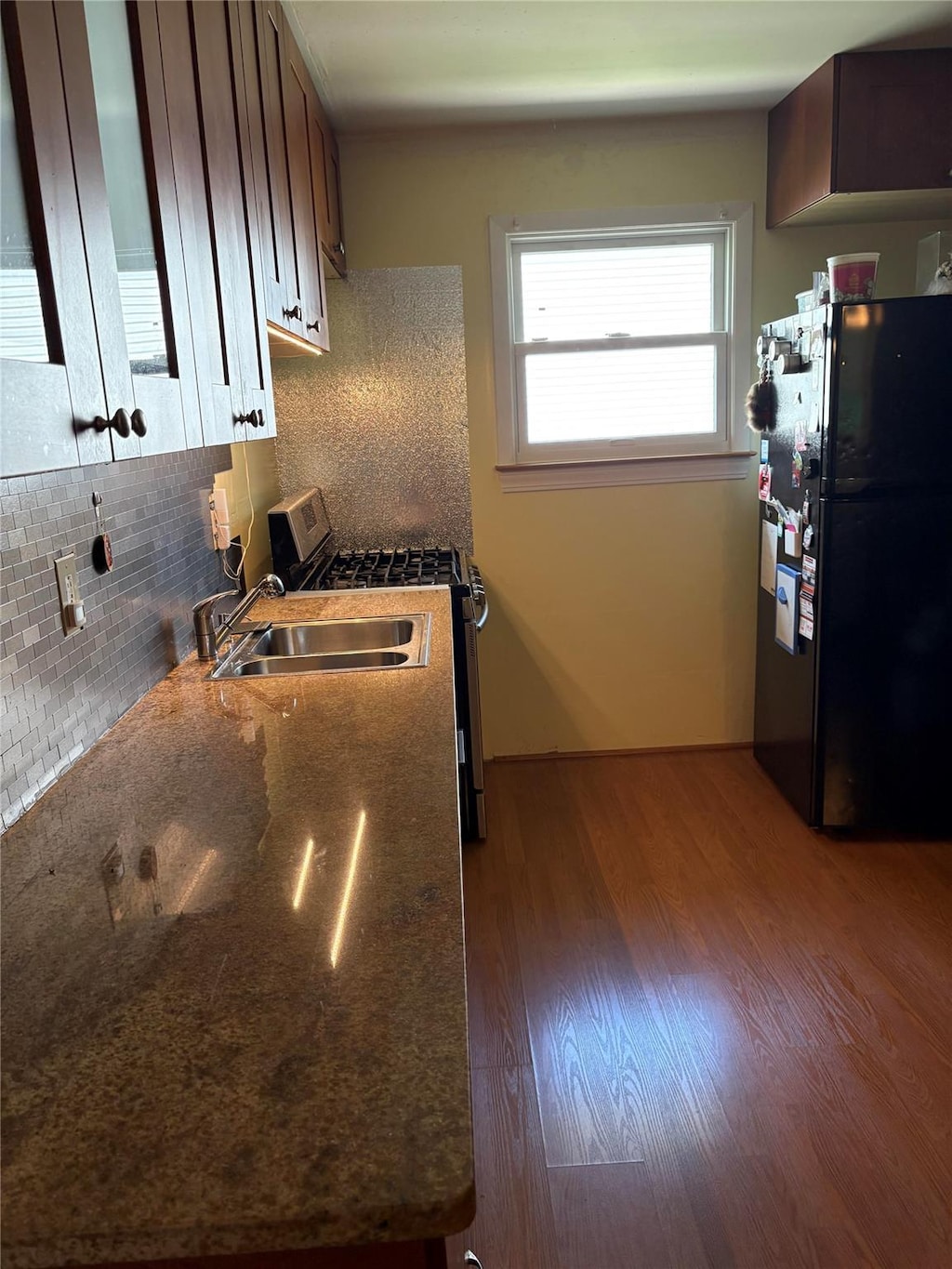 6 Poplar Rd, Amityville, NY 11701 - kitchen featuring freestanding refrigerator, gas stove, backsplash, wood finished floors, and dark stone counters