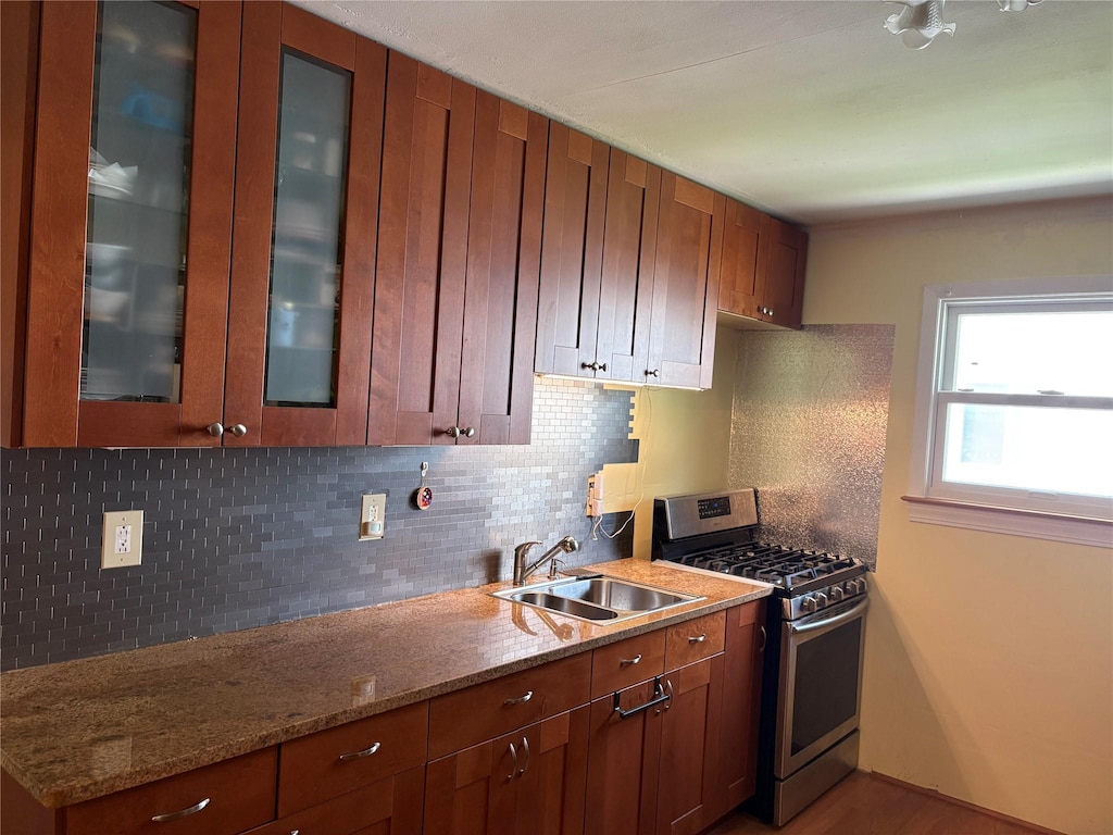 6 Poplar Rd, Amityville, NY 11701 - kitchen featuring stainless steel gas stove, tasteful backsplash, glass insert cabinets, and light stone countertops