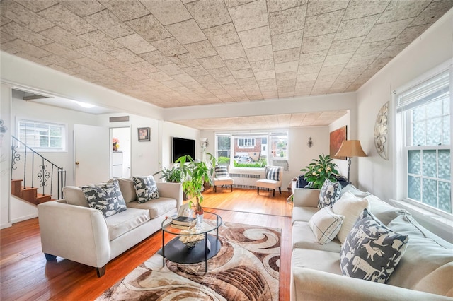 73 Bismark Ave, Valley Stream, NY 11581 - living area with wood-type flooring, stairway, and radiator heating unit