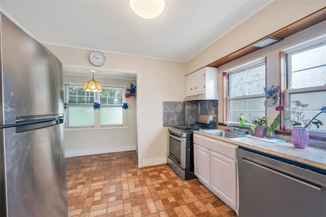 73 Bismark Ave, Valley Stream, NY 11581 - kitchen with stainless steel appliances, white cabinets, brick patterned flooring, decorative backsplash, and pendant lighting