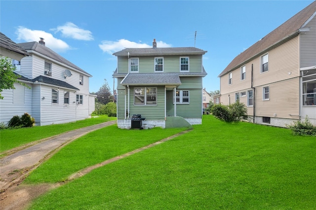 73 Bismark Ave, Valley Stream, NY 11581 - rear view of house with a lawn, a shingled roof, and a chimney